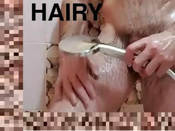 A handsome muscular and hairy guy takes a shower