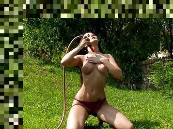 Sexy brunette masturbates with the help of a water hose