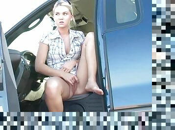 Blonde chick with hot tits rubs her pussy lips in a car