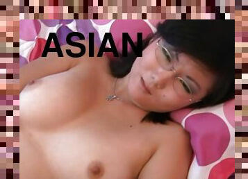 Asian chick in glasses plays with her shaved pussy