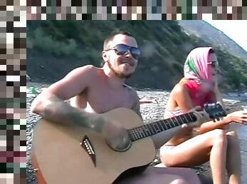 He plays guitar for her and fucks her on the beach