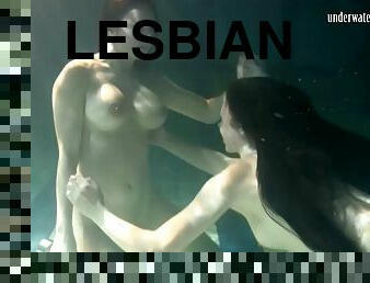 Two sexy babes remove their clothes while being under the water