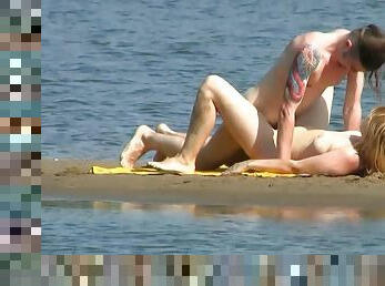 Tattooed fucker is drilling babe on the beach