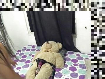 Lesbiana monta al oso de peluche con arnés.