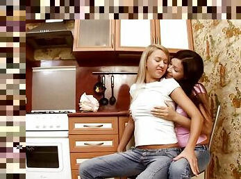 A blonde and a brunette playing lesbian games in the kitchen