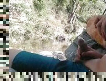 Boy playing with himself in a condom near a river