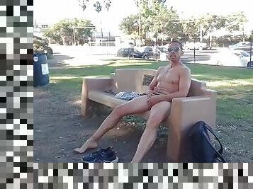 Risky public jerking completely naked on a park bench with traffic in the background