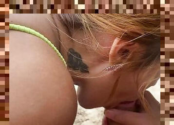 Girl giving blowjob in the middle of the beach during the day