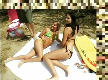 Sunbathing beach babes share a lucky guy's fat cock