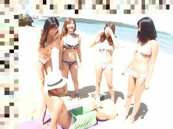 A few Japanese skanks share a prick on a beach in group sex scene