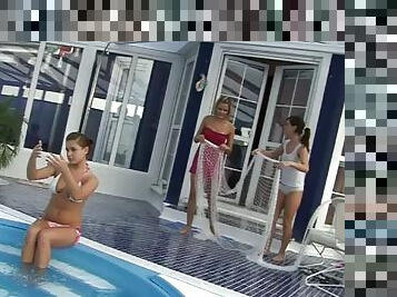 Three muff divers play with a huge dildo beside a pool