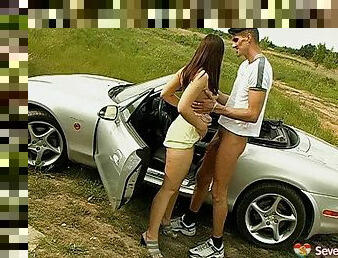 Teen bimbo sucking a man's cock in a convertible car