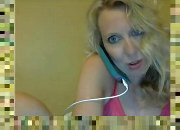 Sexy blonde milf on phone chatting and stripteasing in front of webcam