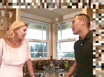 Tattooed Asian dude fucks a hot blonde milf in the kitchen