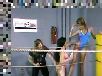 Two lesbians wearing swimsuits fight on a ring in retro clip