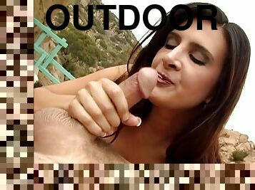 Gorgeous brunette Ava Ramone gives hand to a guy outdoors