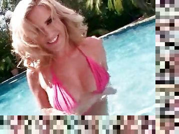 Blonde sex bomb squeezing tits by the pool