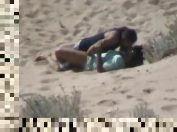 Amateur couple banging on a beach get caught on a voyeur's cam