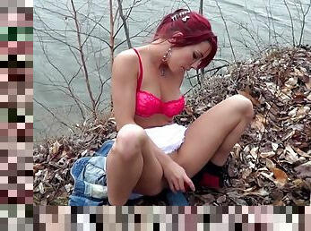 Horny redhead Shana Lane toys her coochie near a pond