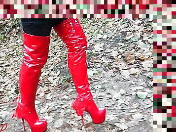 Lady L sexy walking with extreme red boots in forest.