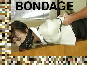 Hogtied on desk . . .