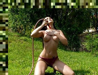 Sexy brunette masturbates with the help of a water hose