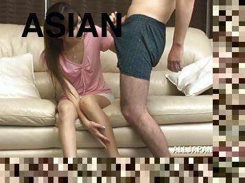 Horny Asian babe sucks on a guy's cock as he lays on a couch