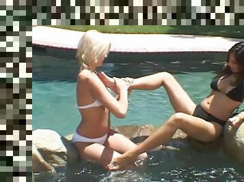 Delightful lesbian babes lick feet by the pool