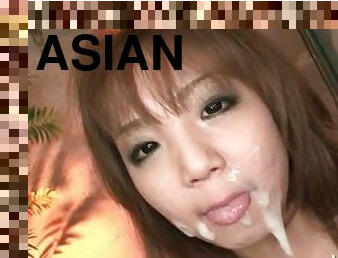 Asian slut blowing two cocks gets a messy facial