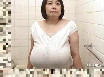 Huge-breasted mature Japanese lady gives a titjob to a horny man