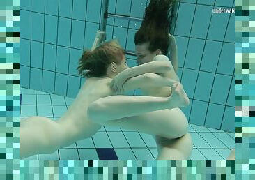 Two lusty brunette bints strip each other under the water