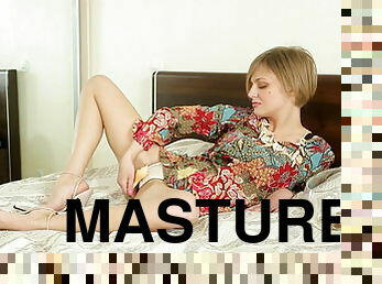 Short-haired teen masturbates on a bed