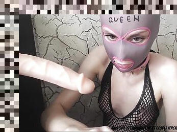 Young blonde in a mask sucks attached to the wall dildo