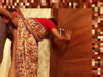 Excited Indian couple peeping through keyhole