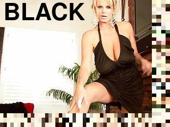 Kelly Madison wears a black dress while sucking on a man's dick