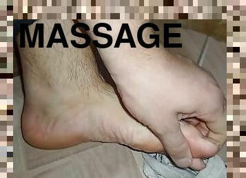 Man comes home from work and the first thing he does is to massage his feet.