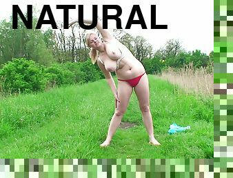 Chubby blonde shows her big natural tits and toys her cunt outdoors