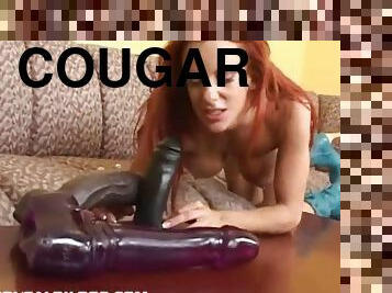 Sexy cougar with long red hair playing with a huge plastic cock