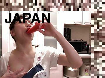 A horny Japanese MILF fucks some food on the kitchen floor