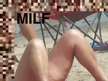 MILF with sexy legs on the beach voyeur video