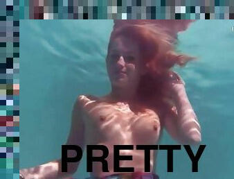 Redhead in a pretty dress takes us underwater