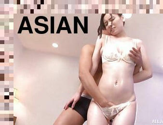 Erotically inclined Asian bitch oils up her body and fucks her lover