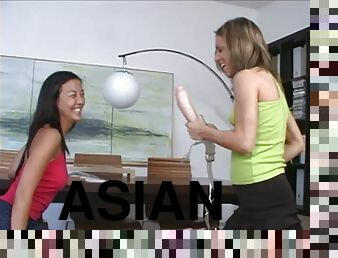 Asian lesbian gets fucked by a white blonde with a big strapon dildo