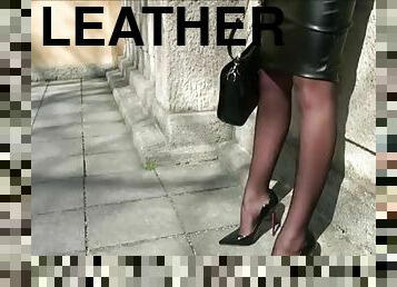 Lady in a hot leather skirt is walking