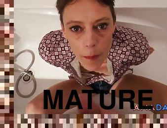 Short hair mature takes facial in the bathtub