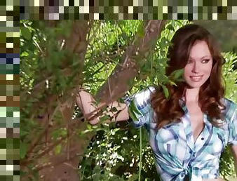 Stunning Kimberly Phillips poses on camera lying on the lawn