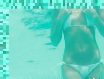 Girl with a perfect tight body swims in her bikini