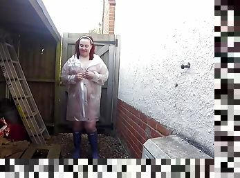 sexy wife Haley outdoors in plastic mac and Wellingtons