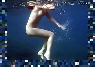 Naked redheaded beauty swims in the ocean