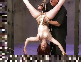 He uses a vibrator to torture her while she's hanging upside down